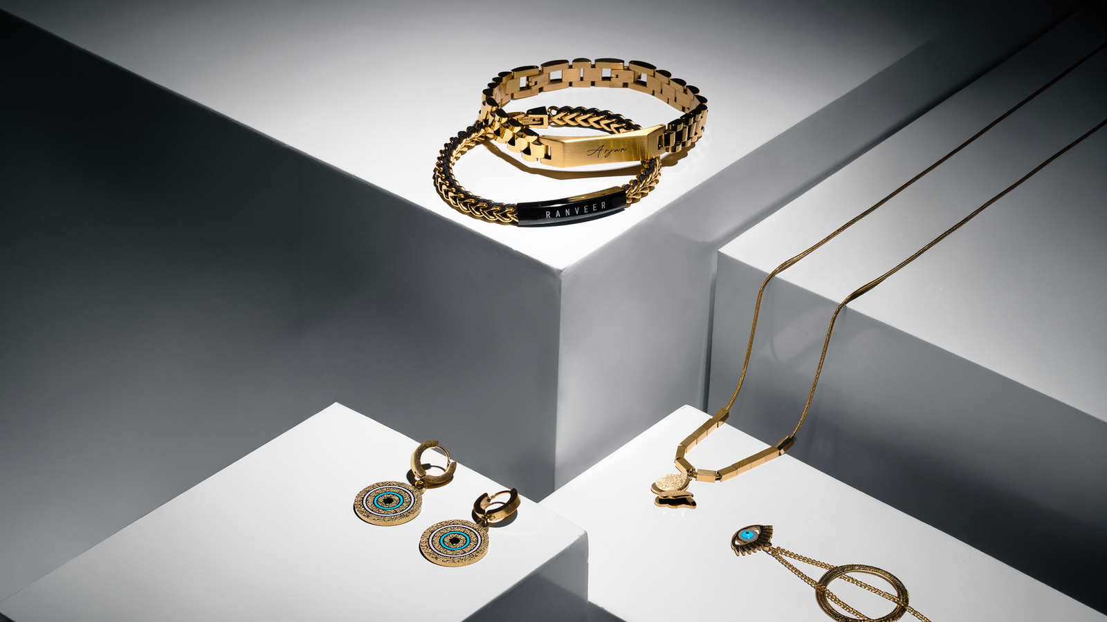 Customised jewellery — engraved steel and 22K gold plated bracelet, name pendant, kada and ring arranged together